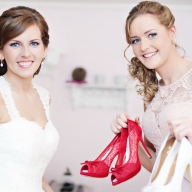 Eine Braut mit ihrer besten Freundin peösentieren deren Schuhe