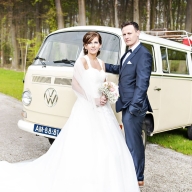 Braut und Brüutigam vor ihrem Hochzeitsauto