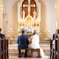 Braut und Bräutigam sitzen vor dem Altar ind einer Kirche