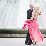 Braut und Bräutigam tanzen vor einer Fontaine