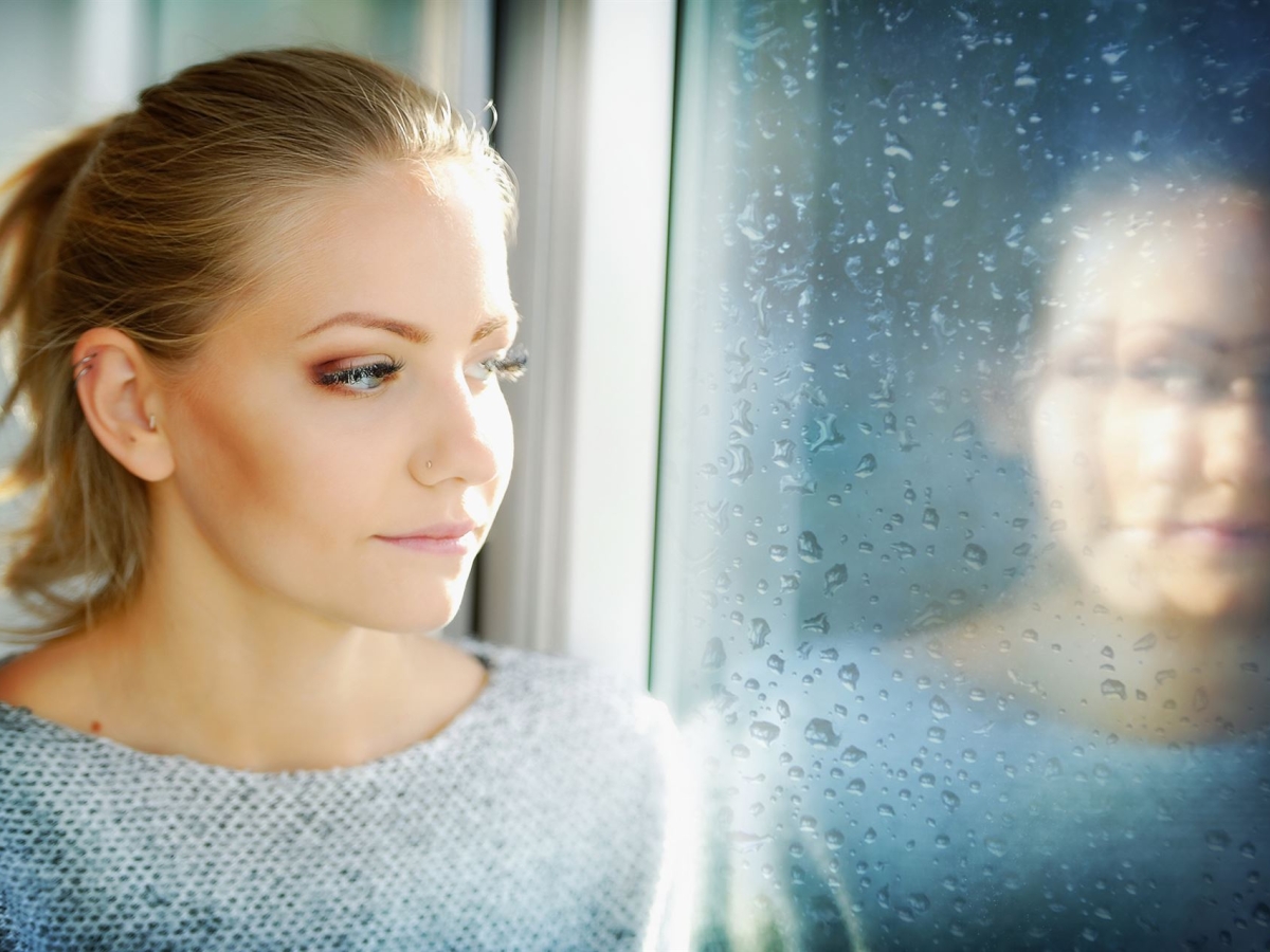 Eine junge Frau schaut in ein Fenster