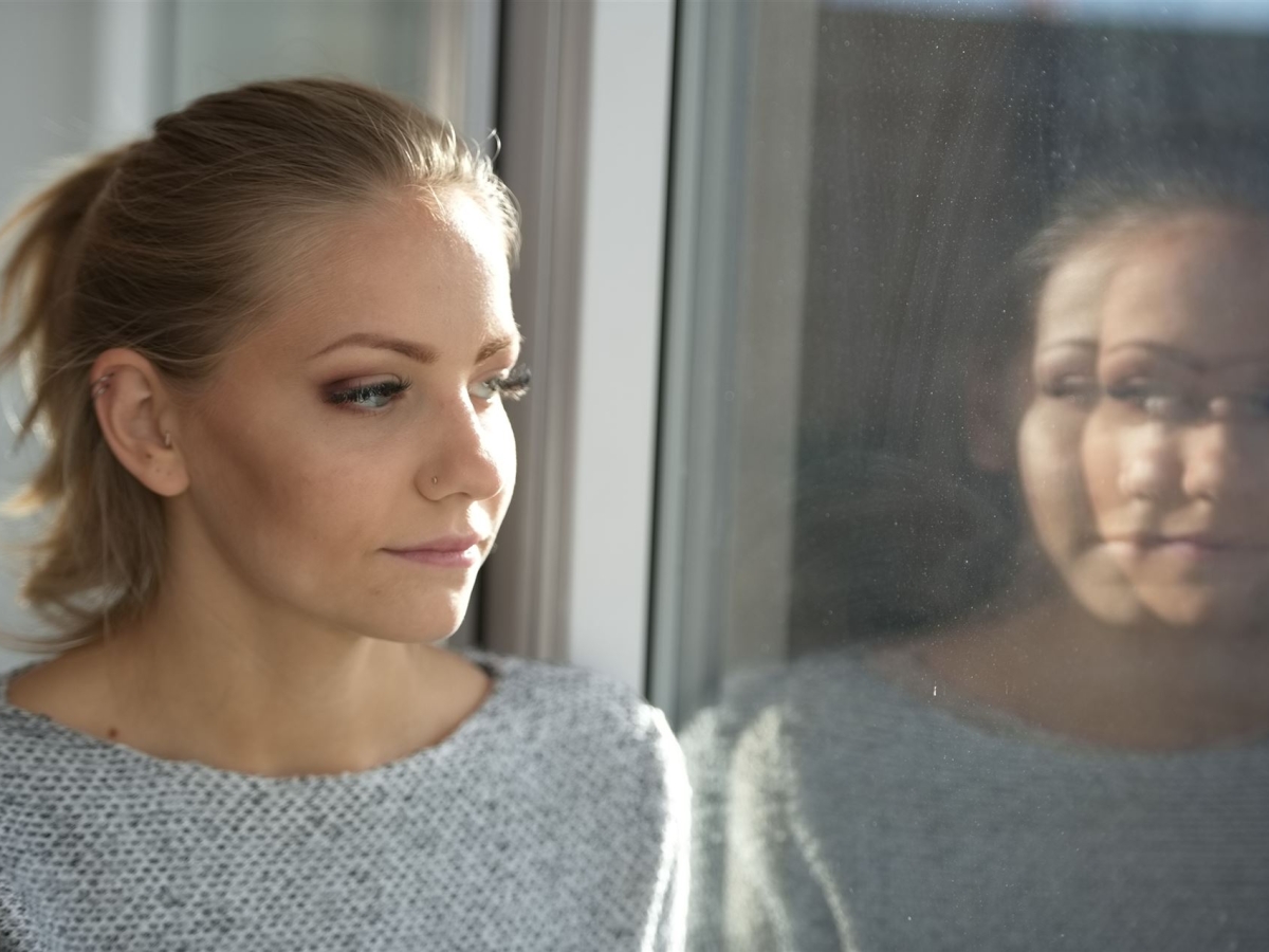 Eine junge Frau schaut in ein Fenster